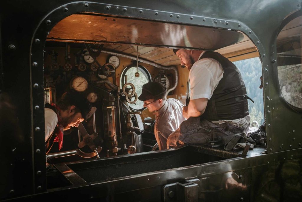 Furka Cogwheel Railway steam locomotive cabin interior with operators controlling heritage steam engine instruments and gauges