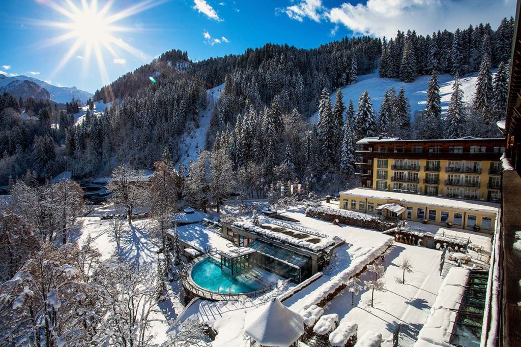 Lenkerhof Gourmet Spa Resort and outdoor pool surrounded by snow in Lenk