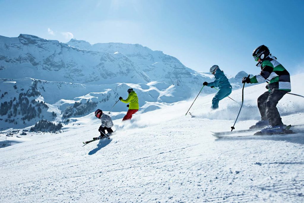 Skiers descending a snowy slope in Adelboden, Switzerland