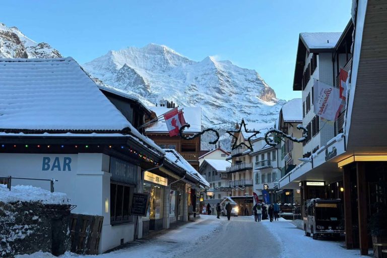 Snow-covered street in Wengen with the Swiss Alps in the background