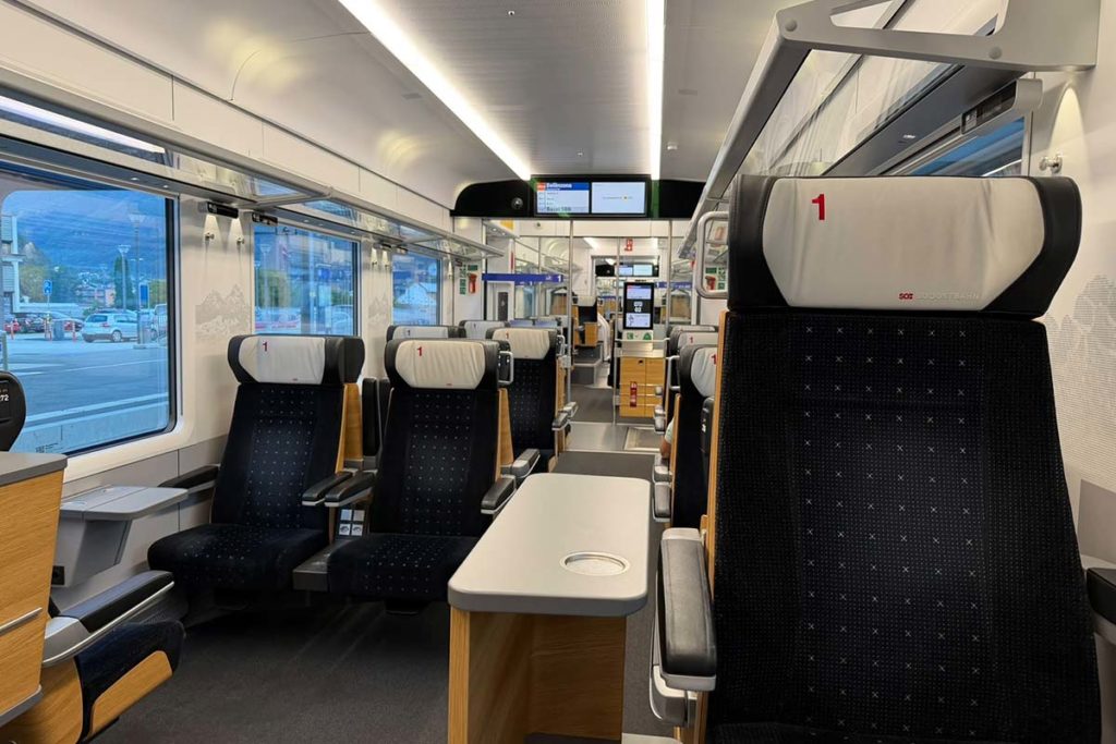 Spacious first-class carriage on the Treno Gottardo with comfortable seats, tables and large windows